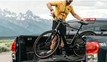 A man places a Fiido C21 electric bike in the bed of a truck