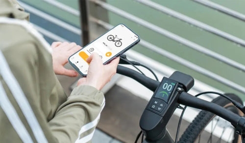 A woman is using the Fiido APP to connect a Fiido e-bike.