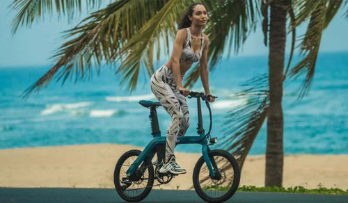 A fit woman is riding a fiido D11 electric bike on the beach