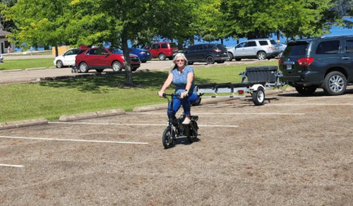 A woman on a Fiido L3 e-bike near the parking lot.