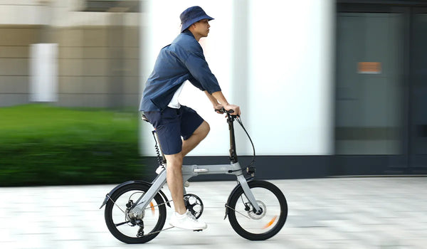 A man riding a Fiido D11 electric bicycle on a city road.