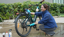 A woman is maintaining her electric bike.