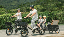 A man is riding a T3 Max Cargo E-Bike while carrying his child.