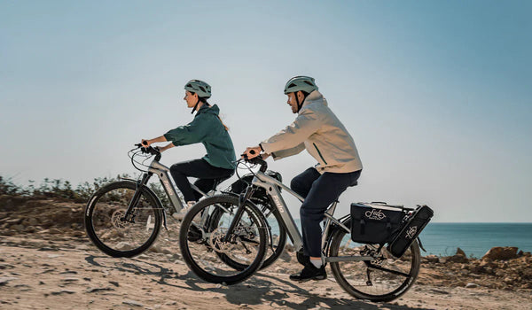 A couple is riding their Fiido Nomads Pro e-bikes along a mountain road.