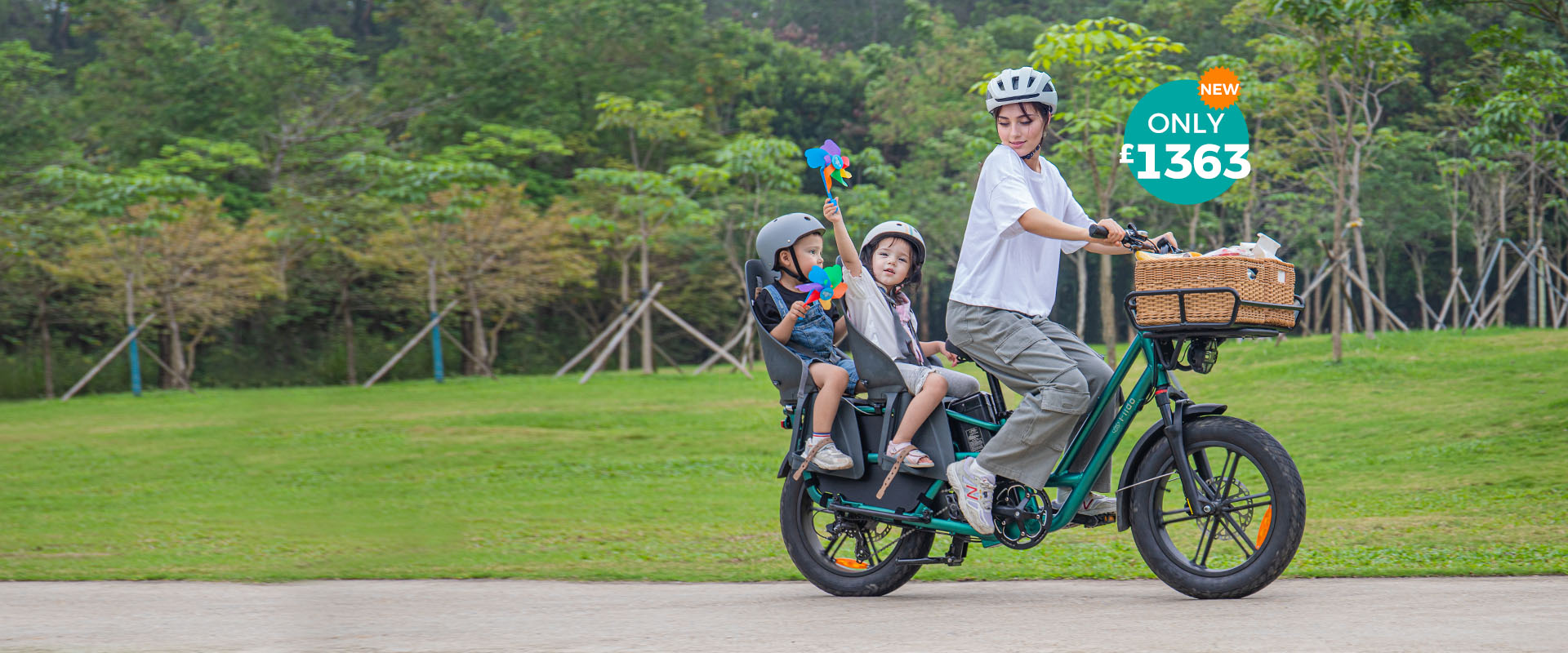 A woman rides a Fiido T2 electric bike with two kids, who are holding pinwheels.